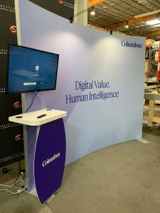 RENTAL: RE-1094 Inline Design with Symphony Large Concave Curved Extrusion Frame, SYM-401 Workstation Counter with Two Wireless Charging Ports, SYM-402 Workstation Counter, Monitor Mount, 32" Monitor, RE-1255 Reception Counter, (2) LED Arm Lights, SEG Fab